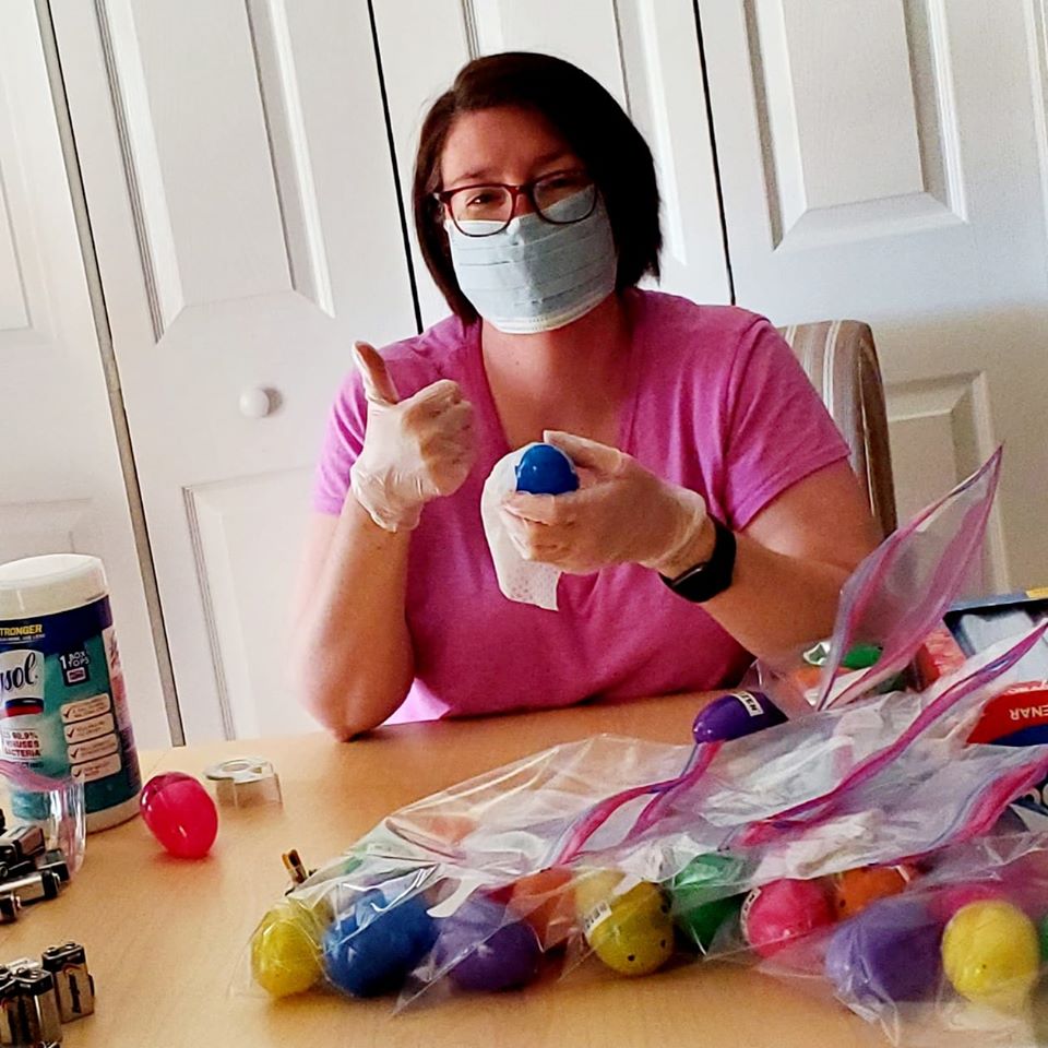 In this photo, New Vision's CEO Chantel Buck dons a mask and plastic gloves to test and sanitize beeping eggs for each family.