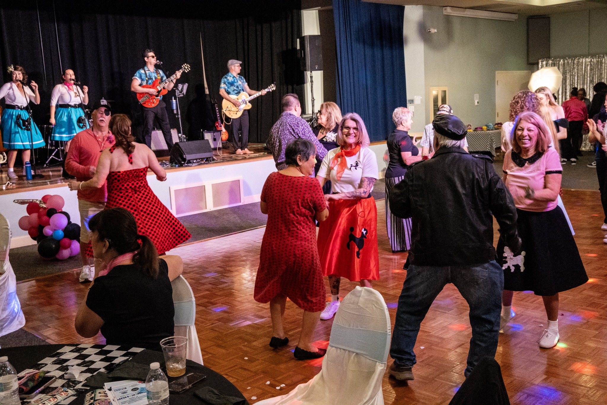 Guests dance on the dance floor during the Senior Citizens Prom while the band plays on stage in the background.
