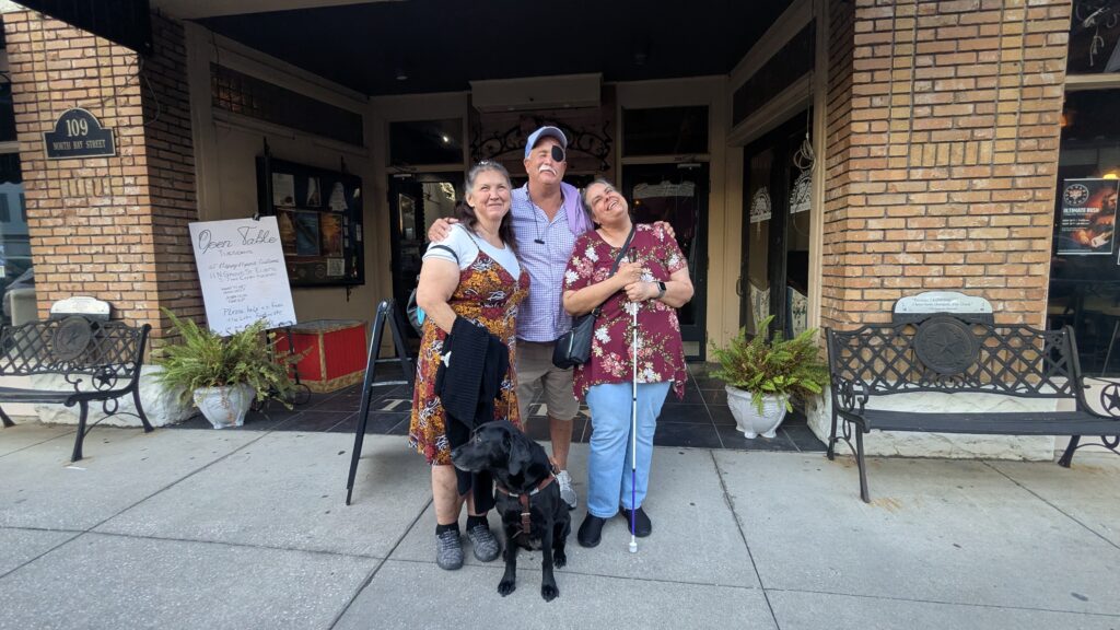 From left, New Vision's Christy, Scott and Maurine stand in front of the theatre before the show and pose for a picture. Rosie the service dog sit at their feet in front of them.