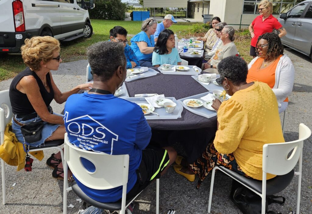 A group of folks sitting around tables outside