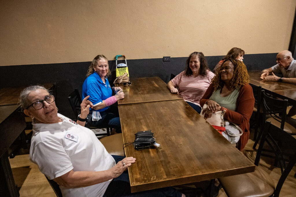 New Vision staff and clients sit at a table at Brick and Barrell before the Celtic music performance at the library.
