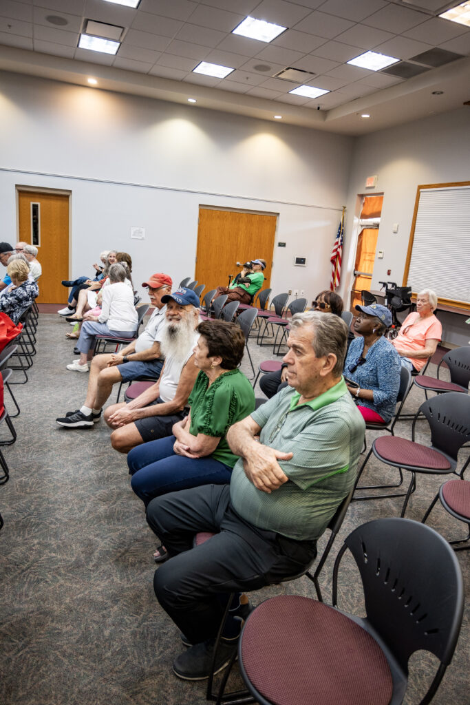New Vision clients sit in a row of seats, waiting for the music to start at the Leesburg Library.

