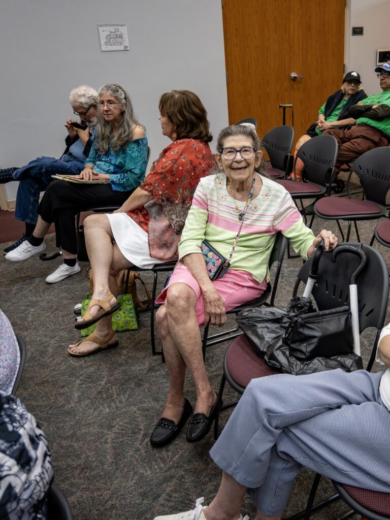 A New Vision client smiles for a photo from her seat at the Celtic Music Performance at the Leesburg Library.
