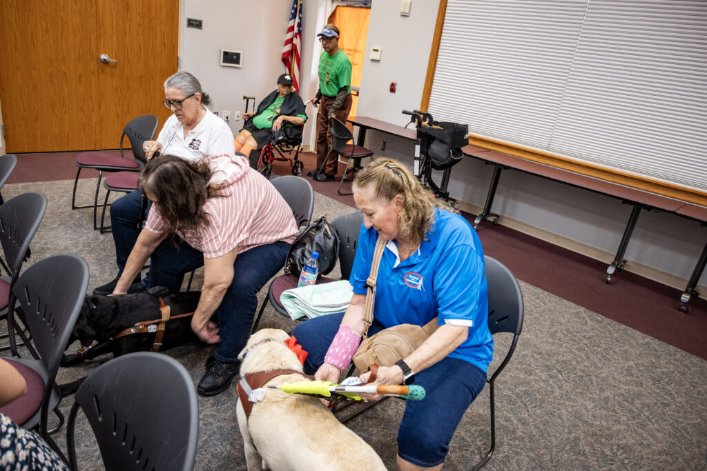 Staff and clients from New Vision settle into their seats and help their service dogs settle in too before the start of the Celtic Music Performance at the Leesburg Library.
