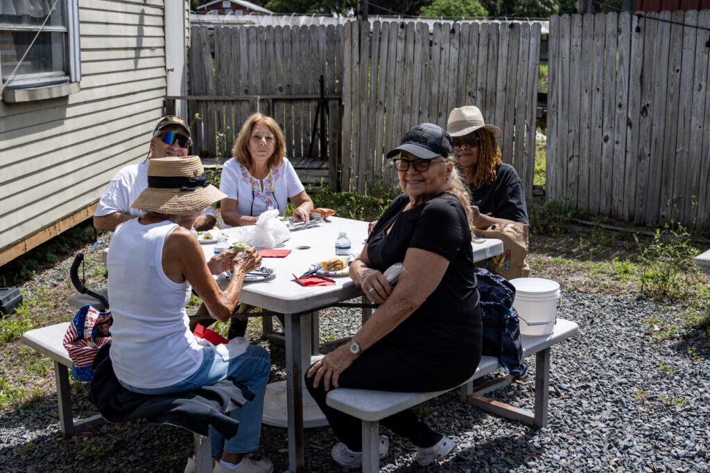 Clients sit around a picnic table for lunch at Blue Bayou Farms.