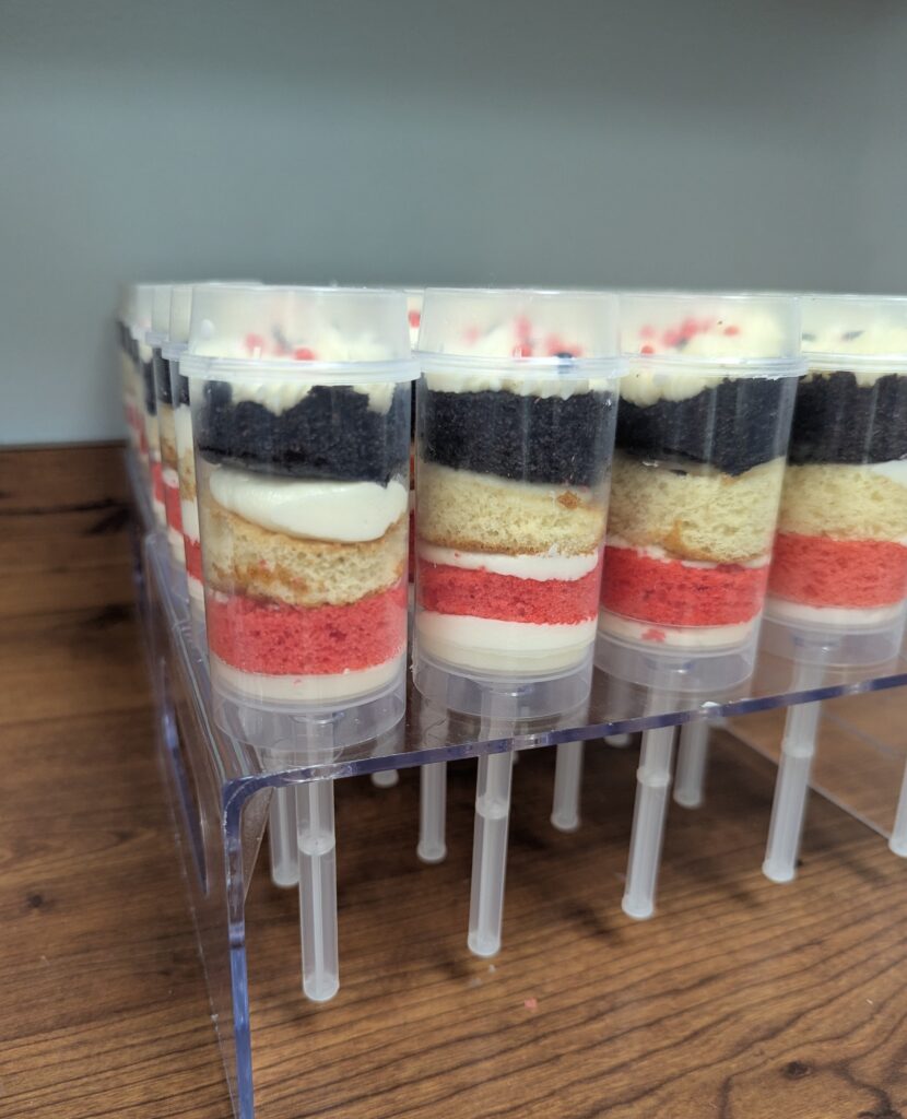 Rows of cake pops sit in a tray, ready to eat.
